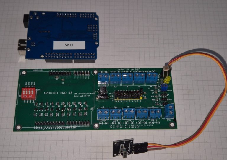 Groen elektronisch circuit met relais en blauwe microcontroller, verbonden met een kabel.