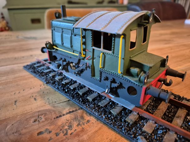 Model van een locomotief op rails, met gedetailleerde afwerking en kleuren.