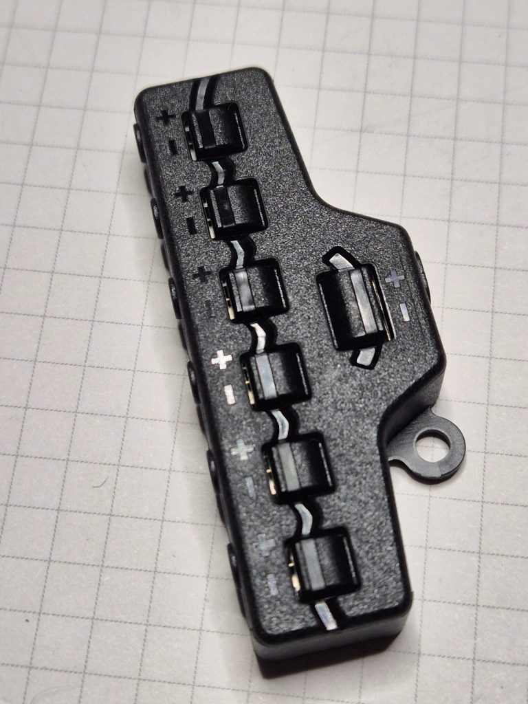 Zwarte schakelkast met meerdere knoppen en een connector aan de zijkant.