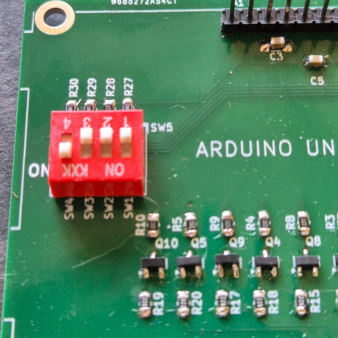 DIP-Switch Arduino UNO printplaat met een rode schakelaar en verschillende componenten.