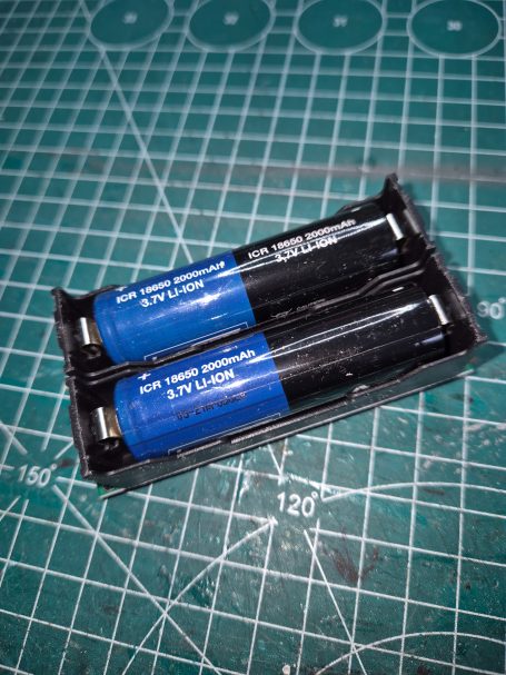 Twee blauwe oplaadbare batterijen in een zwart plastic verpakkingsdoosje.